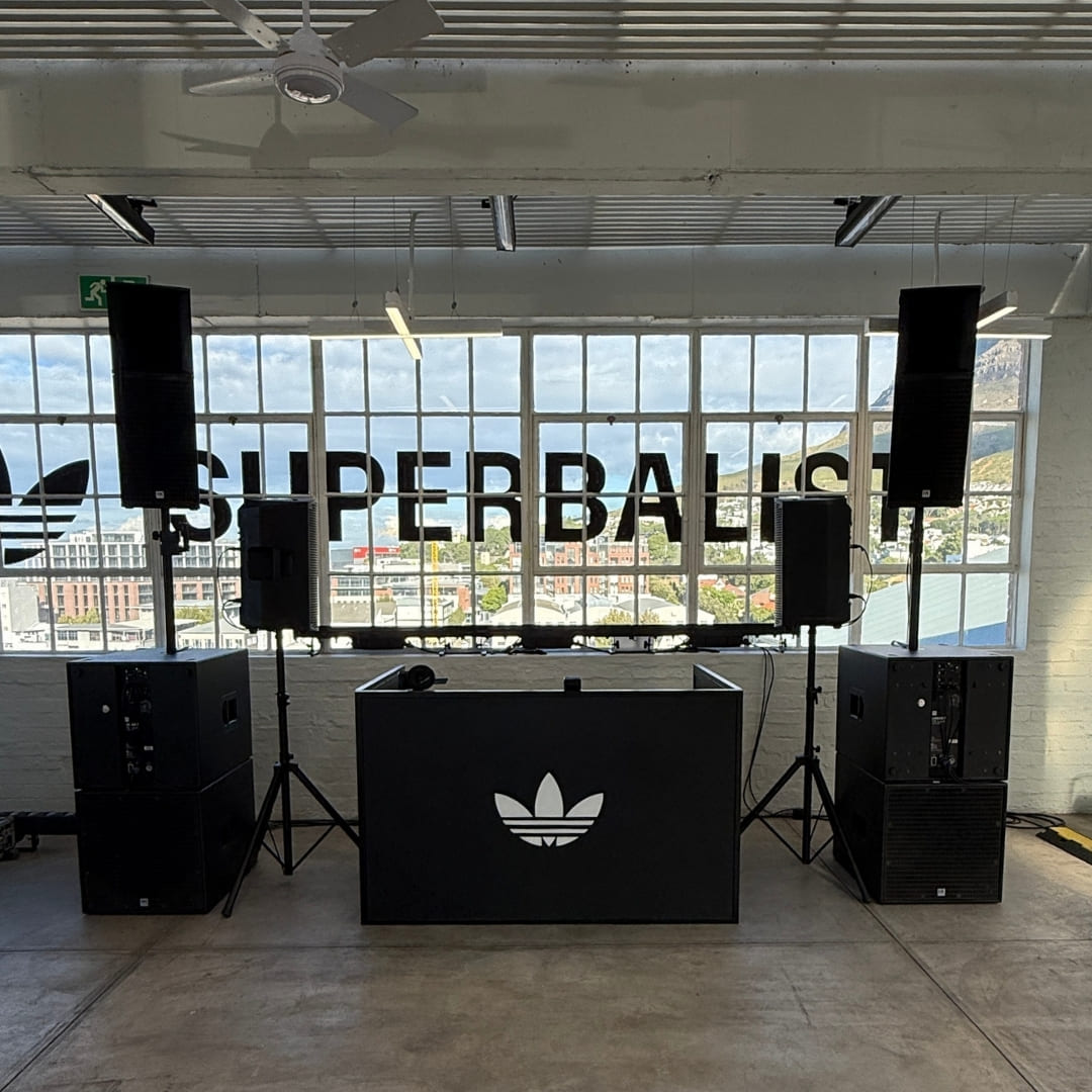 Professional speakers set up for a corporate brand activation with a city view through large windows
