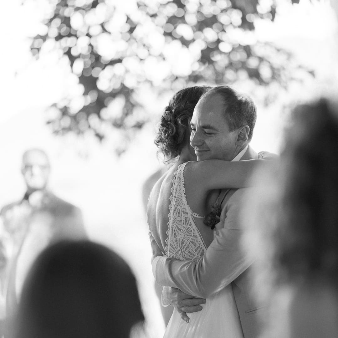 A bride and groom embrace during their first dance in black and white